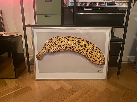 Inramat konstverk med gul banan och leopardmönster